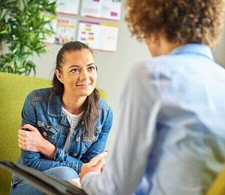 picture of a woman sitting in a chair talking to another person