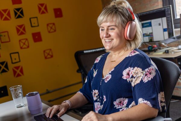 Orbiteer, Shellie, smiling and working at her desk