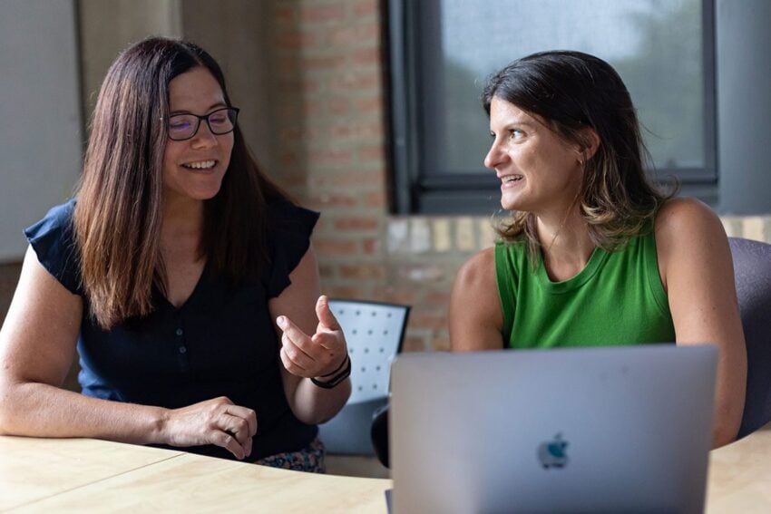 stephanie and mari working together on a computer discussing a website project