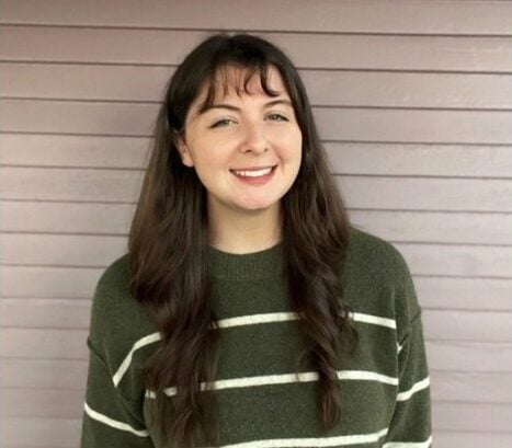 A woman wearing a green and white striped sweater.