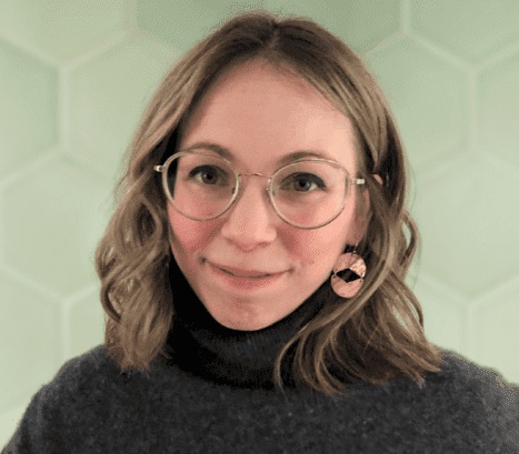 A woman wearing glasses and a turtle neck sweater.