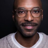 A man wearing glasses and a sweater.