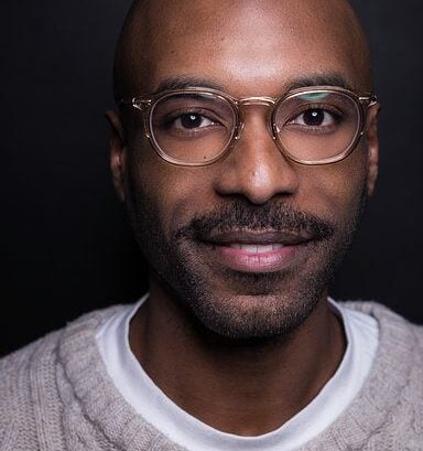 A man wearing glasses and a sweater.