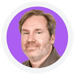 A man with light brown hair and facial stubble is shown in a headshot, wearing a brown shirt, against a purple circular background.